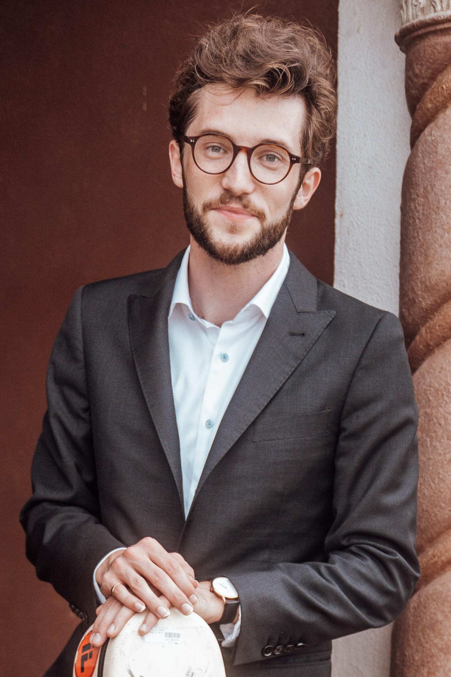 Collin Holloway, classical guitarist, holding guitar and smiling